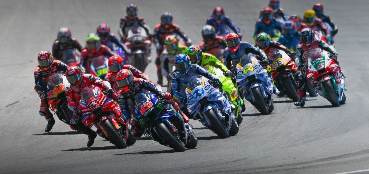 Riders charge into the first corner during a MotoGP race. Photo courtesy Dorna.
