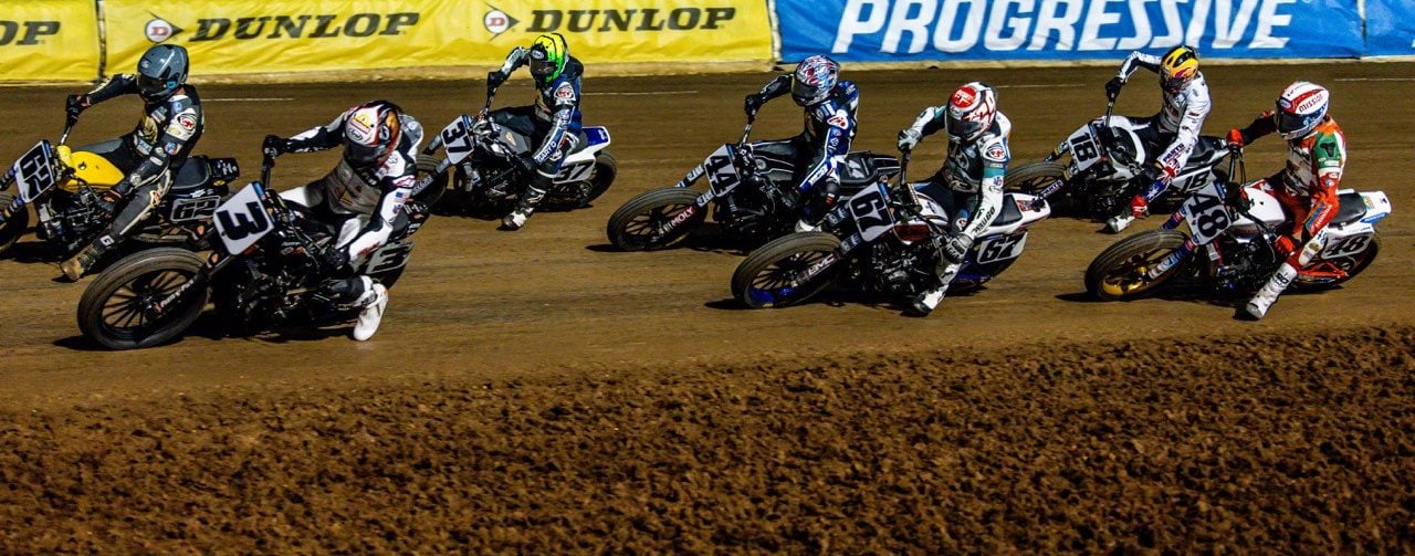 Mission AFT SuperTwins riders Briar Bauman (3), Dan Bromley (62), Davis Fisher (67), Trent Lowe (48), and others race during the Main Event at Lucas Oil Speedway Friday night. Photo by: Tim Lester / courtesy American Flat Track