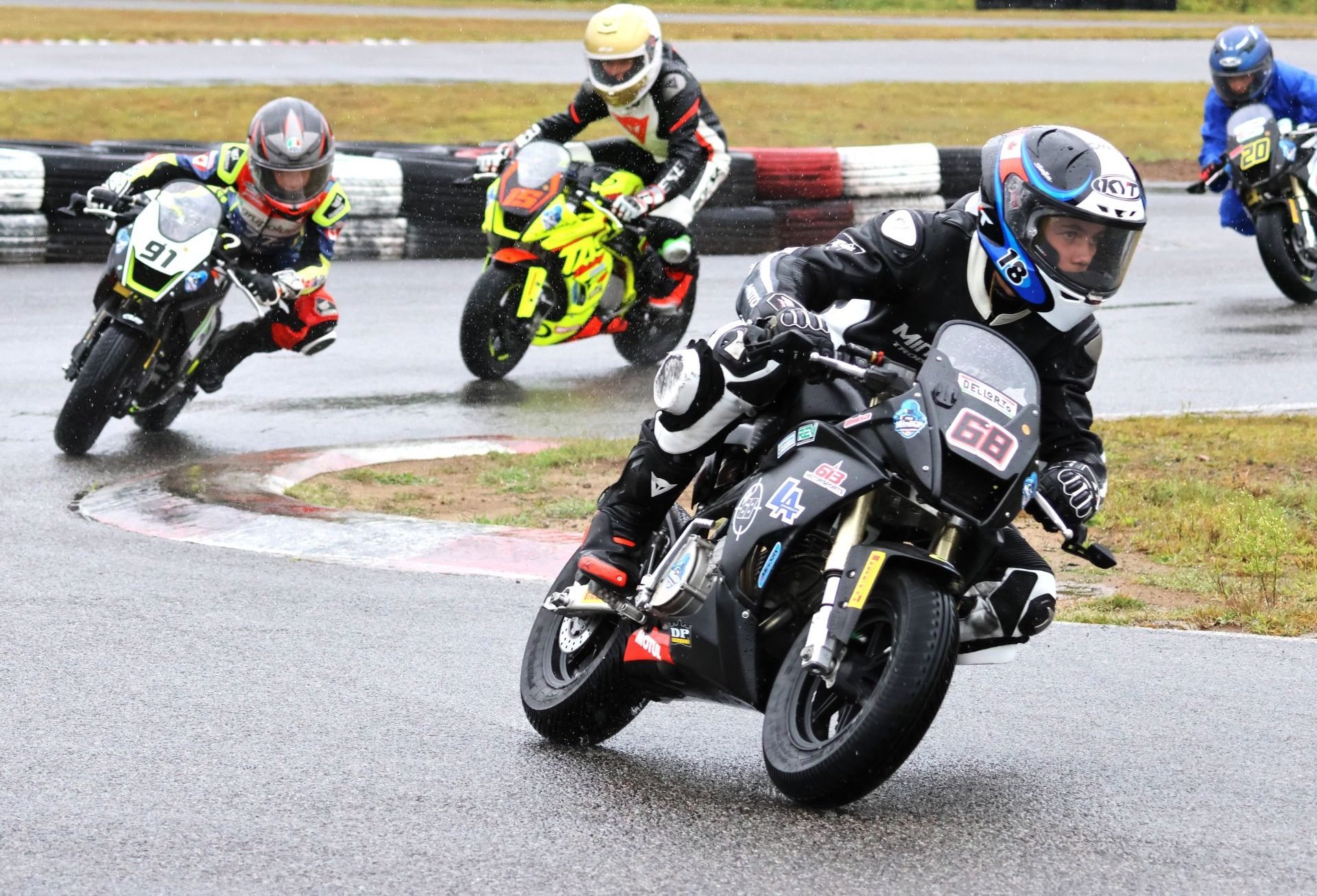 Race one of three, lap one, in the wet Motul FIM MiniGP Canada round two at Le Circuit Mont Tremblant in Quebec, and eventual triple winner No. 68 Jager Stockill, No. 91 Ethan Reardon, No. 15 Stefan Tanasic and No. 20 Martina Cardenas. Eventually earning third, Cardenas made history as the first female to earn the podium at a Mini National round. Photo courtesy Colin Fraser.