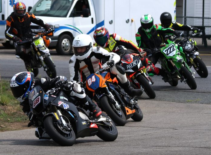 Lap one, turn one of the Moto4 Feature MiniSBK event with the No. 68 613 Cycle Ohvale 160 of eventual winner Jager Stockill leading No. 84 YCF190 of Ben Hodgson, No. 213 Bucci 190 of Jan Massignani, No. 222 Kawasaki KX112 two-stroke of Chelsea Baursier, No. 88 YCF190 of Jacob Abnett, No. 21 Bucci 190 Yan Boursier by CF April 2. Photo courtesy CSBK.