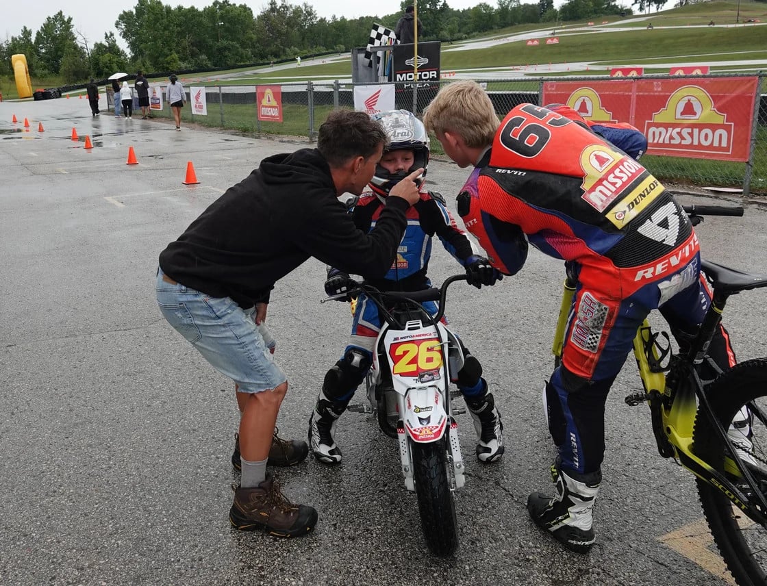 The youngest champion at this year's Mission Mini Cup National Championships was seven-year-old Cruise Texter, who won the Stock 50 class. Here Cruise is greeted by his dad Cory and his riding coach Bodie Paige after winning his race Sunday. Photo by Larry Lawrence