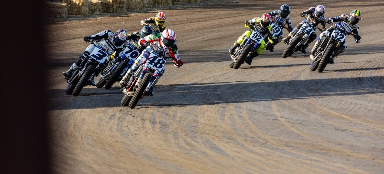 Mission AFT SuperTwins riders Trent Lowe (48), Briar Bauman (3), Dallas Daniels (32), Declan Bender (70), Brandon Price (92) and others round turn four during Race Three Saturday at the Springfield Mile. Photo by Tim Lester / courtesy American Flat Track.