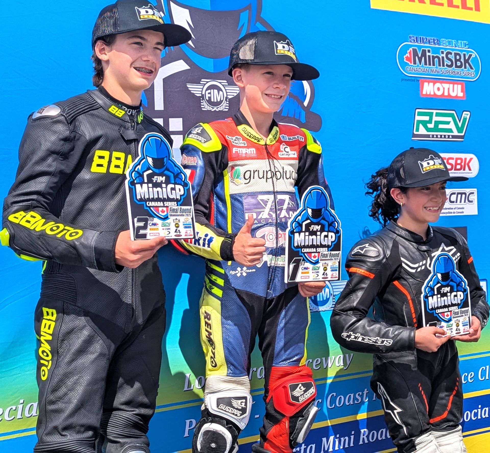 Post race one podium at the third and final round of the Motul FIM MiniGP Canadian Championships at Shannonville Motorsport Park’s Go Kart layout, with (left to right) runner-up Jager Stockill, victor Ethan Reardon and third palced Martina Cardenas. Photo courtesy Colin Fraser