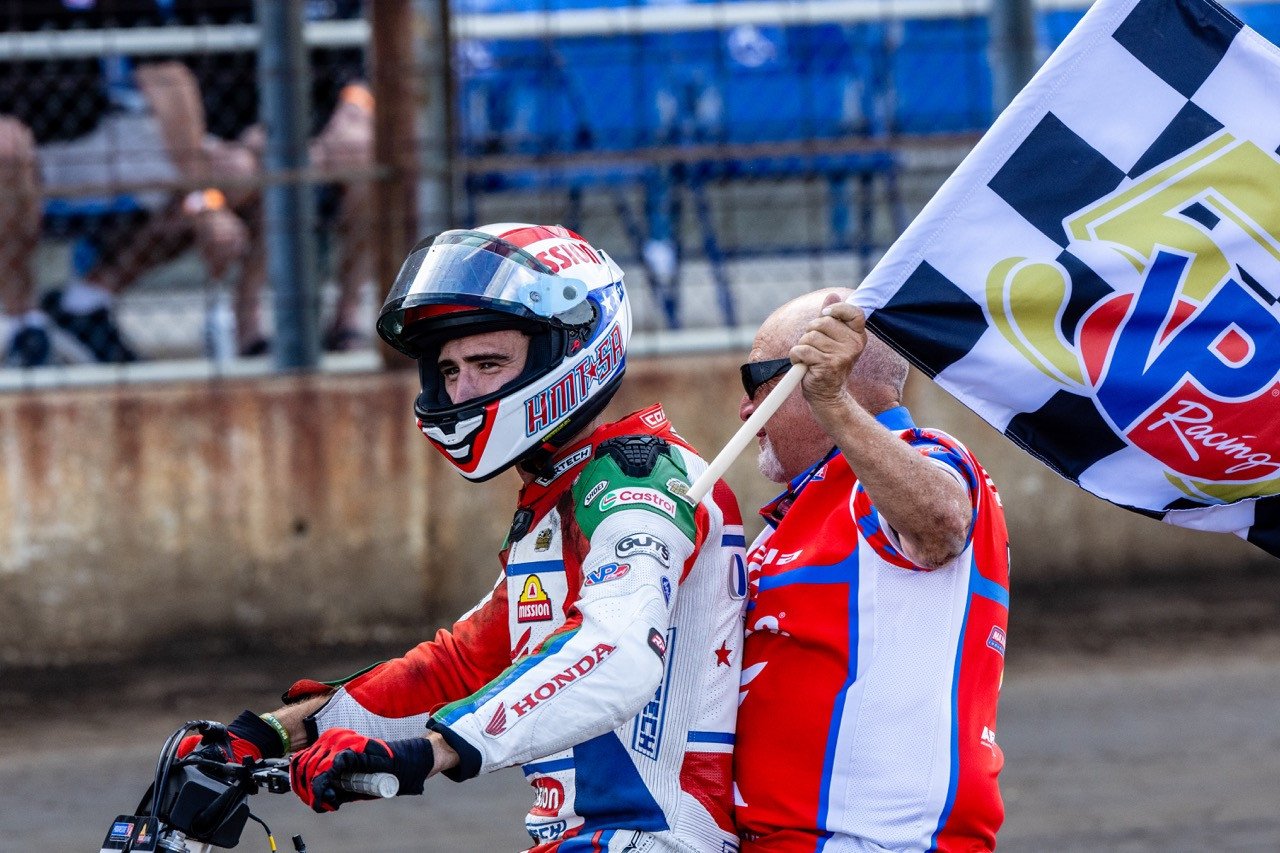 Trent Lowe (48) celebrates his Main Event victory with the team and the checkered flag Sunday. Photo by Tim Lester / courtesy American Flat Track.